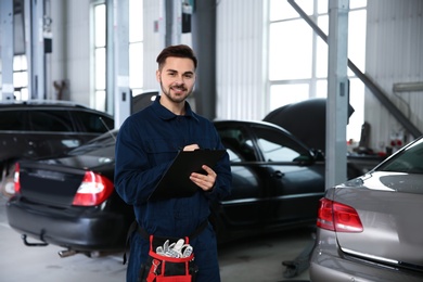 Photo of Portrait of technician with clipboard at automobile repair shop