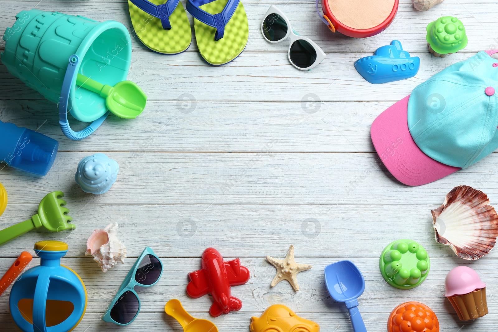 Photo of Flat lay composition with colorful beach toys on wooden background. Space for text