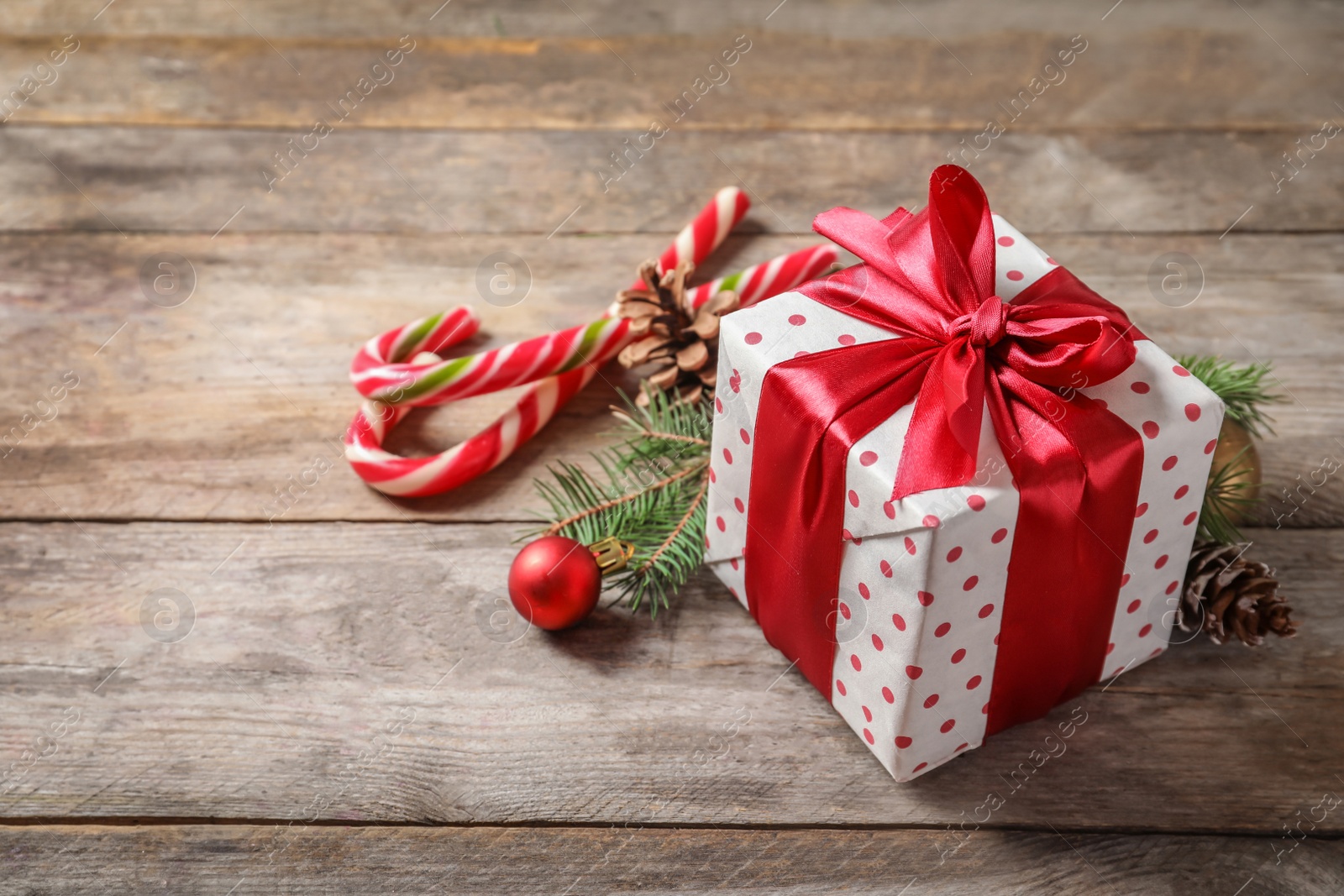 Photo of Beautiful composition with gift box and Christmas decorations on wooden table