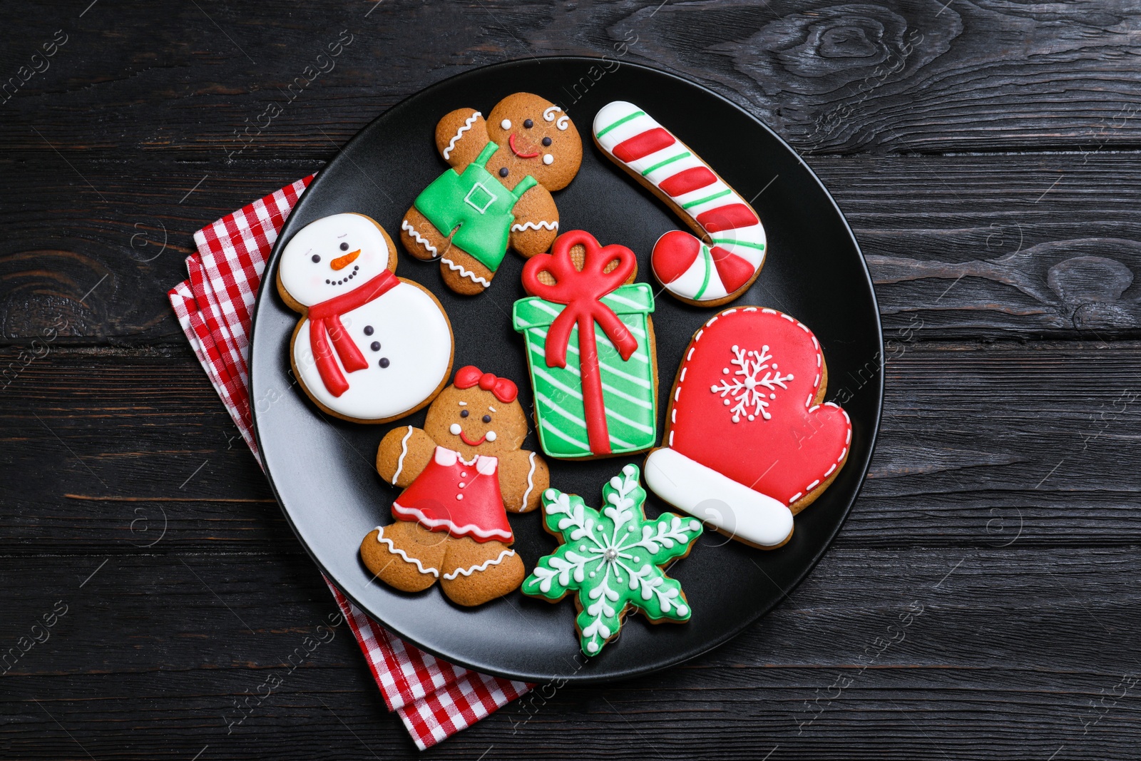 Photo of Delicious Christmas cookies on black wooden table table, top view