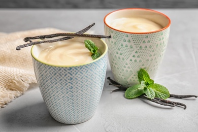 Photo of Vanilla pudding, sticks and fresh mint on table