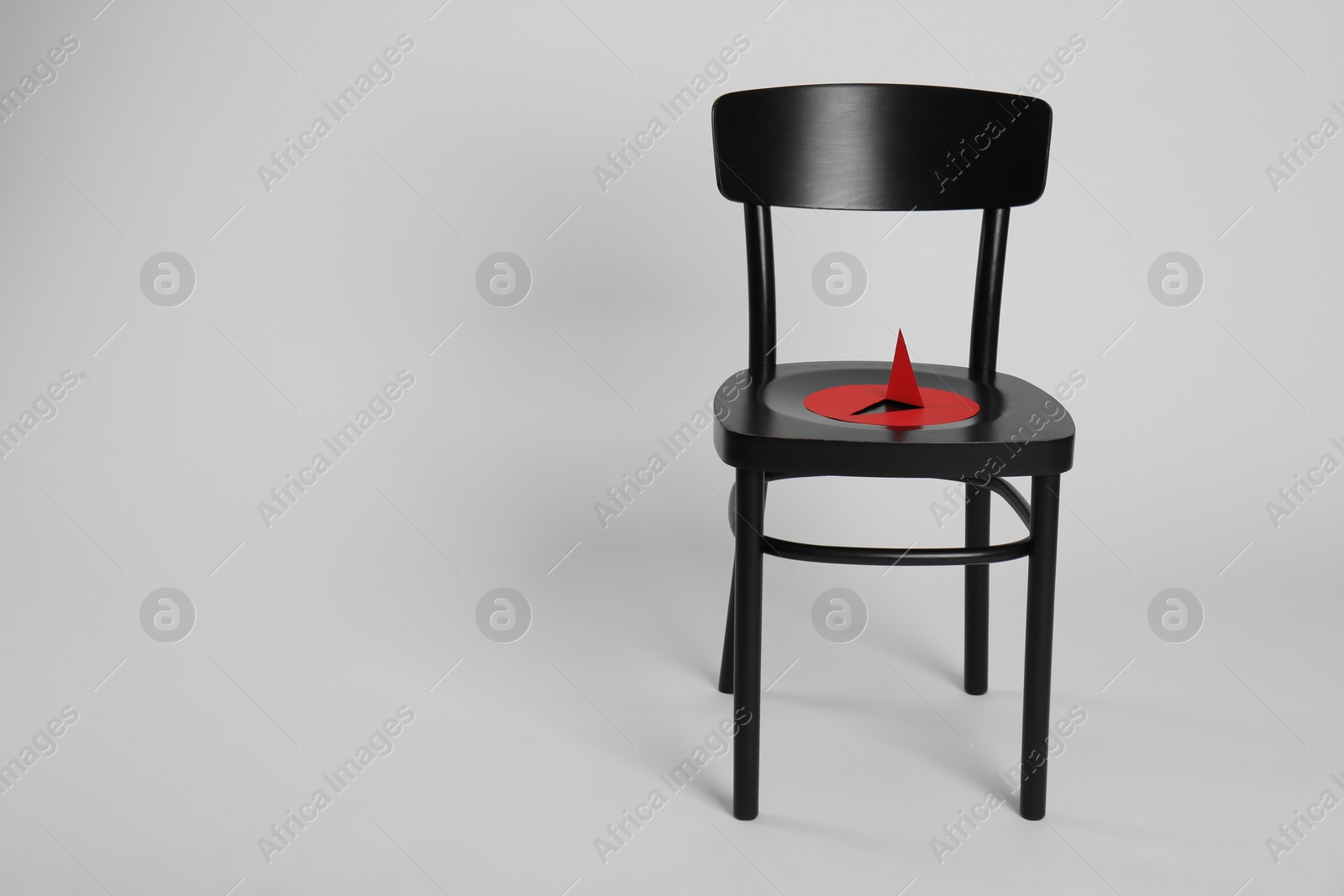 Photo of Chair with large red paper pin isolated on white. Hemorrhoids concept