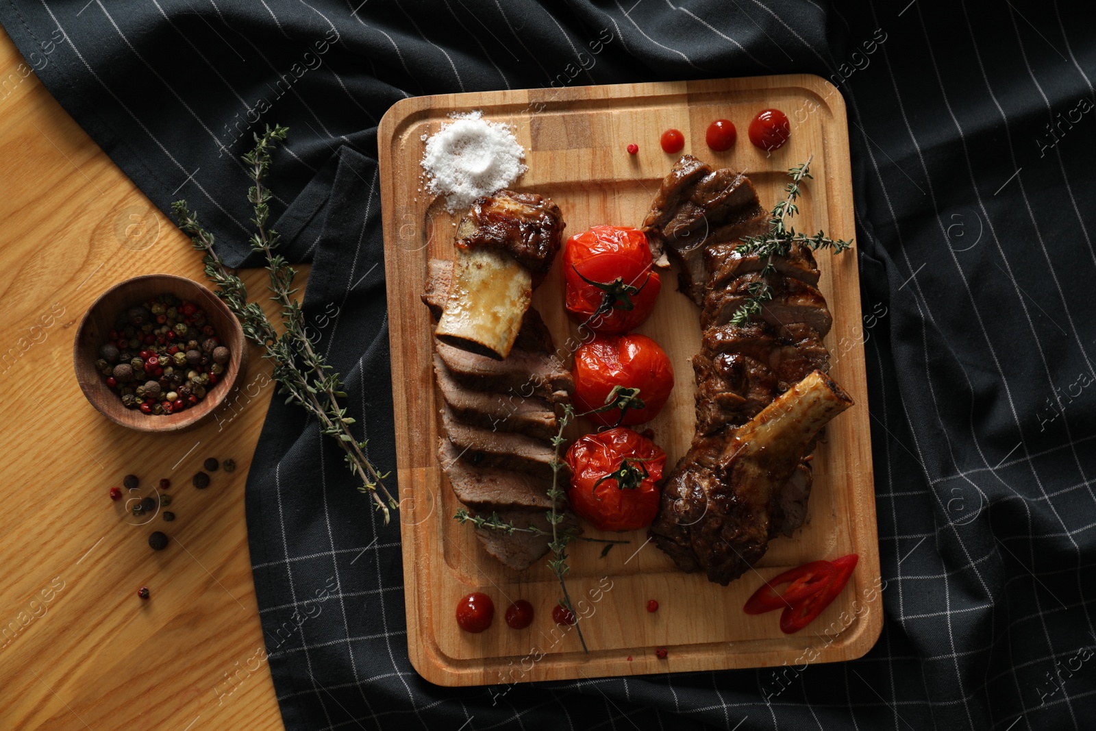 Photo of Delicious roasted ribs served on wooden table, flat lay