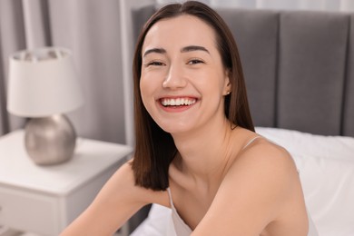 Portrait of beautiful woman laughing in bedroom