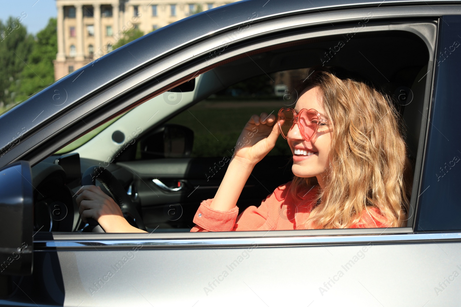 Photo of Happy woman with heart shaped glasses in car