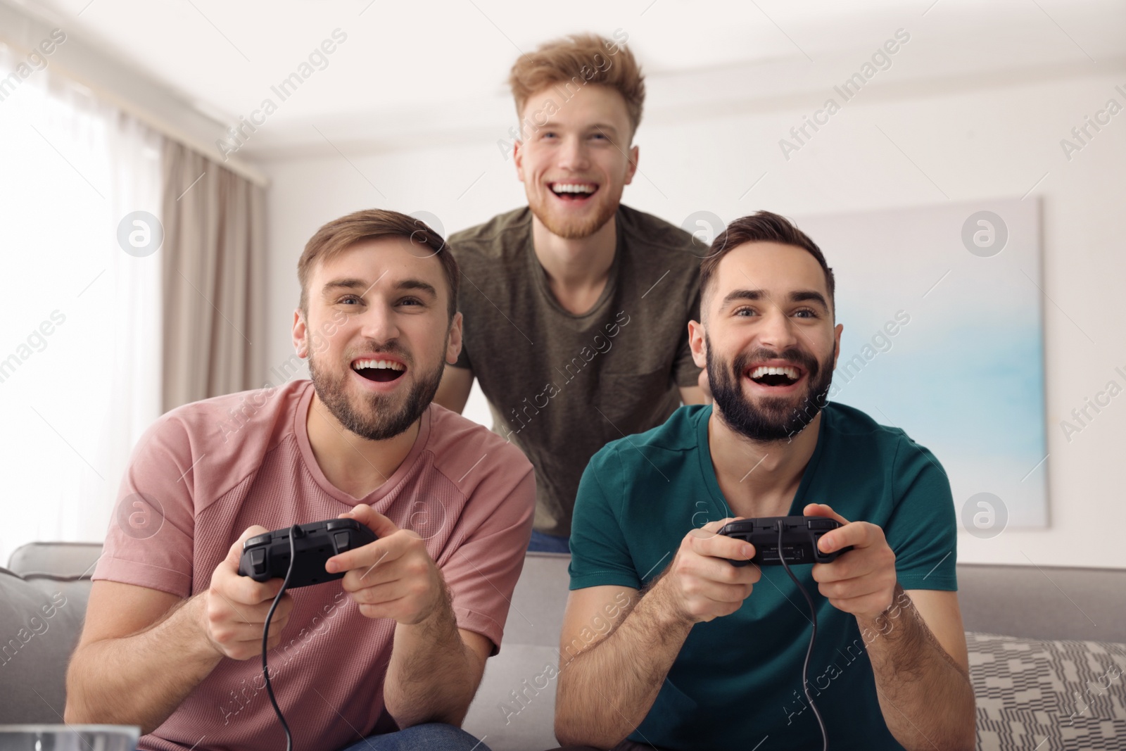 Photo of Emotional friends playing video games at home