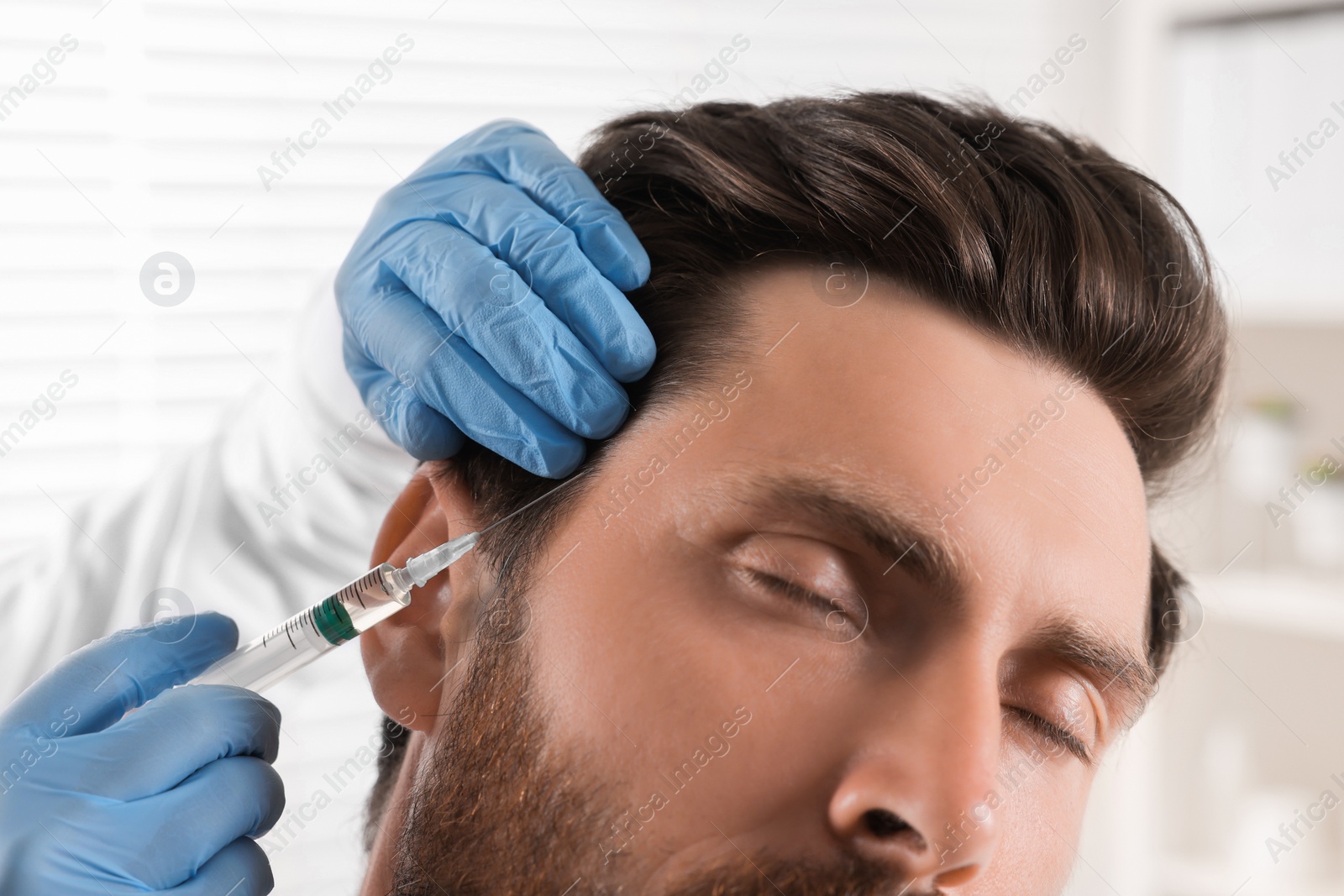 Photo of Trichologist giving injection to patient in clinic, closeup