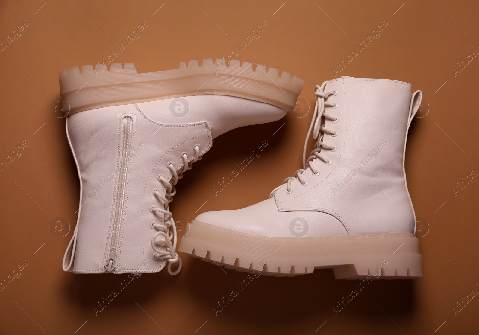 Photo of Pair of stylish leather shoes on light brown background, flat lay