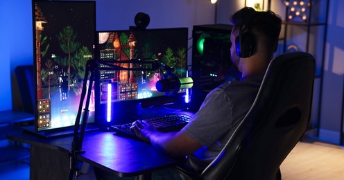 Photo of Man playing video games on computer at table indoors