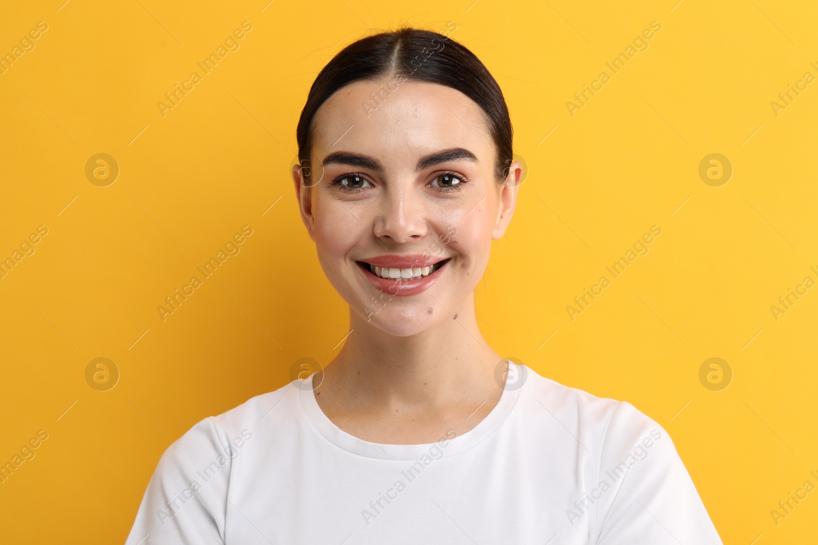 Photo of Beautiful woman with clean teeth smiling on yellow background