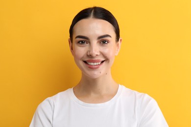 Photo of Beautiful woman with clean teeth smiling on yellow background