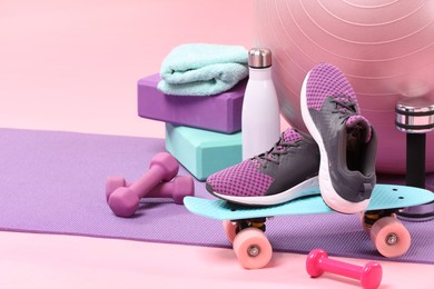 Photo of Many different sports equipment on pink background, space for text