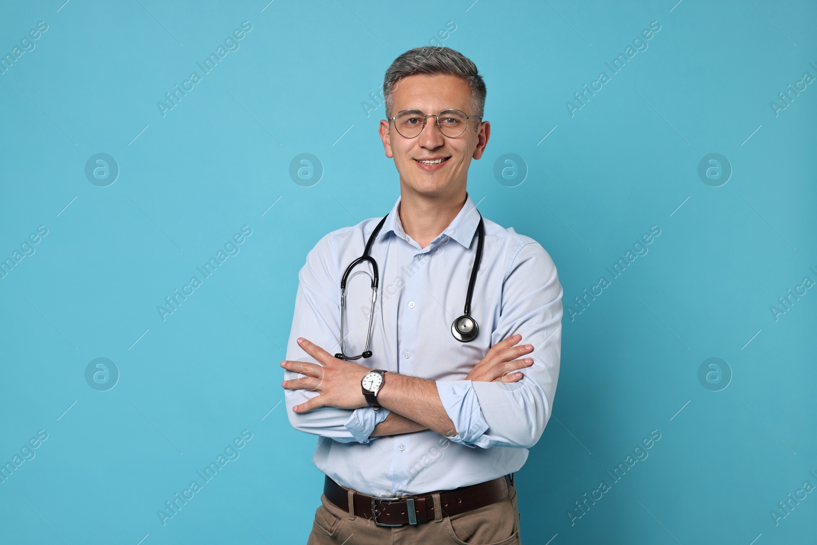 Photo of Doctor with stethoscope on light blue background