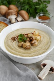 Photo of Delicious cream soup with mushrooms and croutons on beige textured table