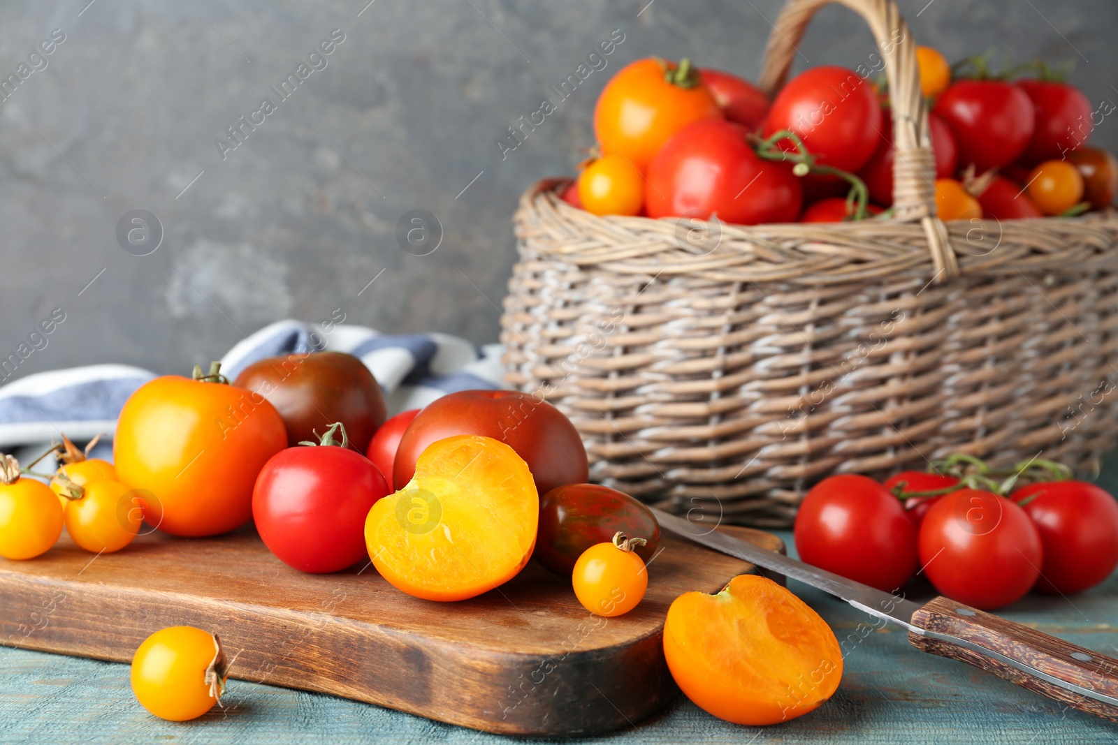 Photo of Composition with fresh ripe tomatoes and wicker basket on wooden table