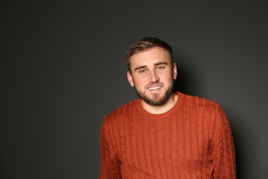 Image of Handsome man wearing warm sweater on dark background 