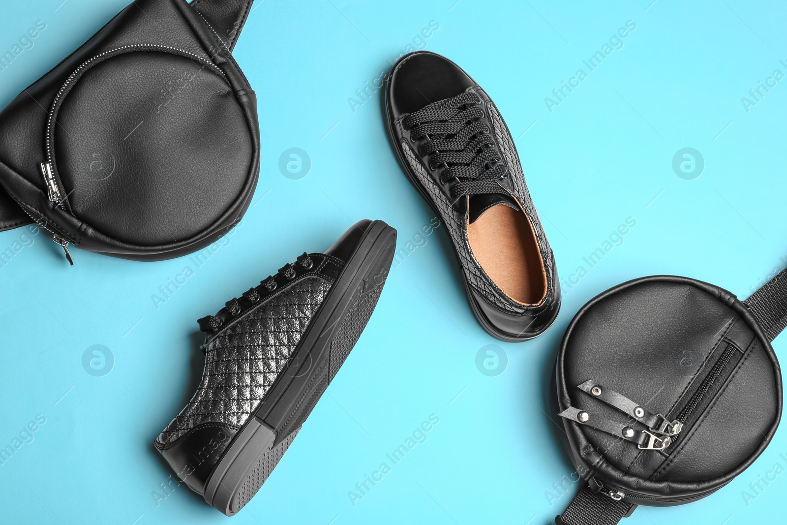 Photo of Flat lay composition of stylish shoes and bum bags on color background