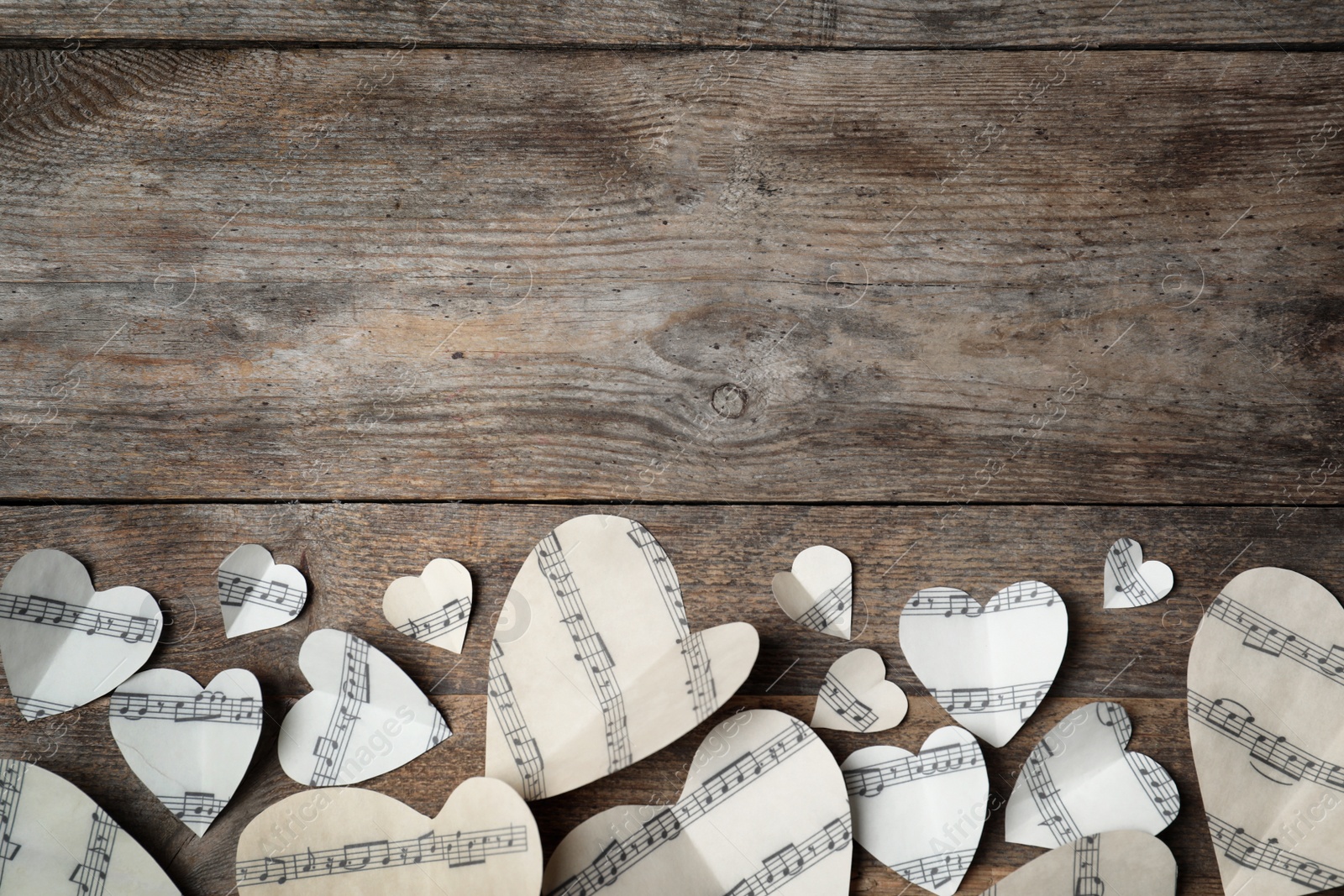 Photo of Paper hearts with music notes and space for text on wooden background, flat lay