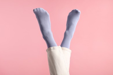 Photo of Woman in stylish purple socks and pants on pink background, closeup