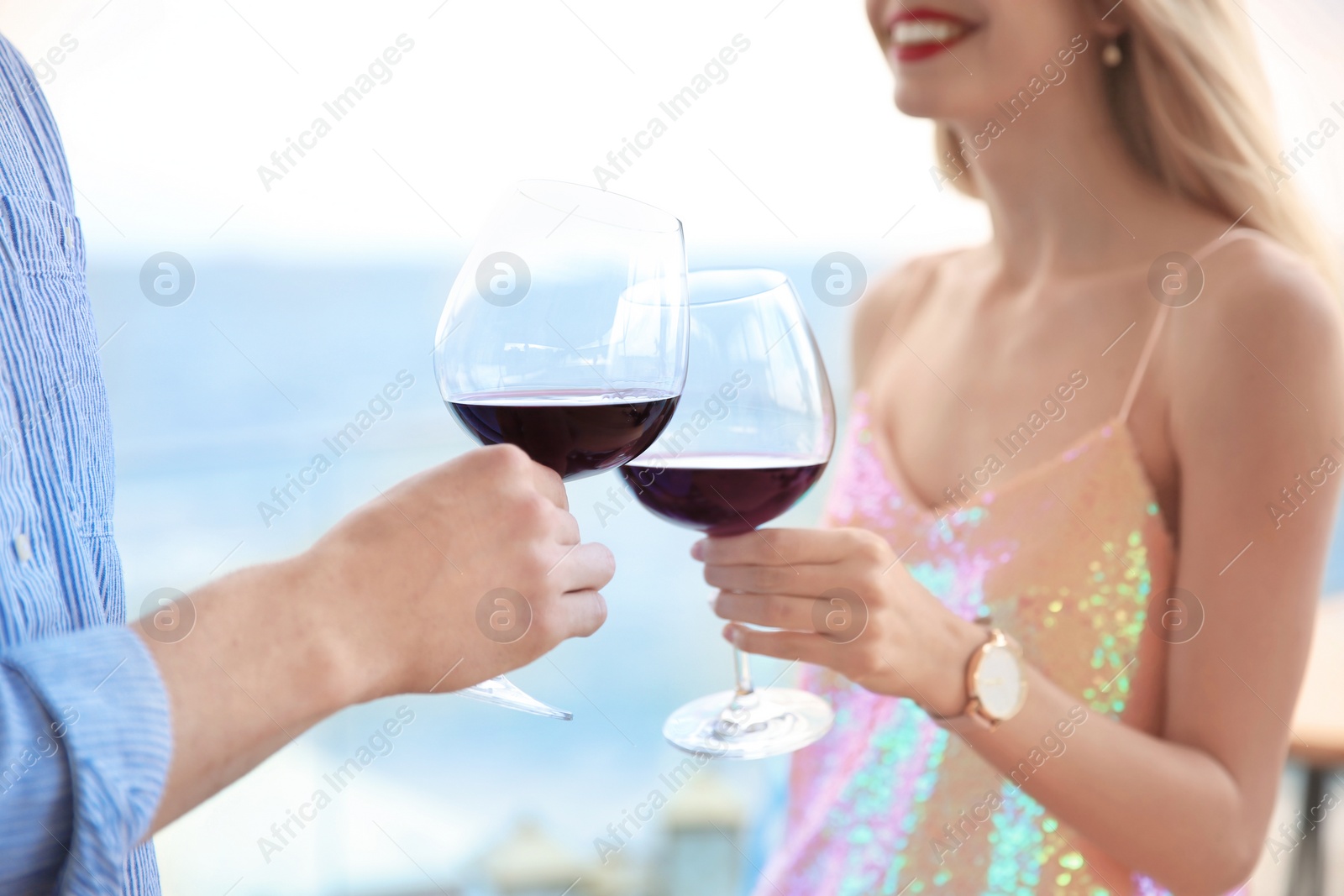 Photo of Young romantic couple with glasses of red wine outdoors