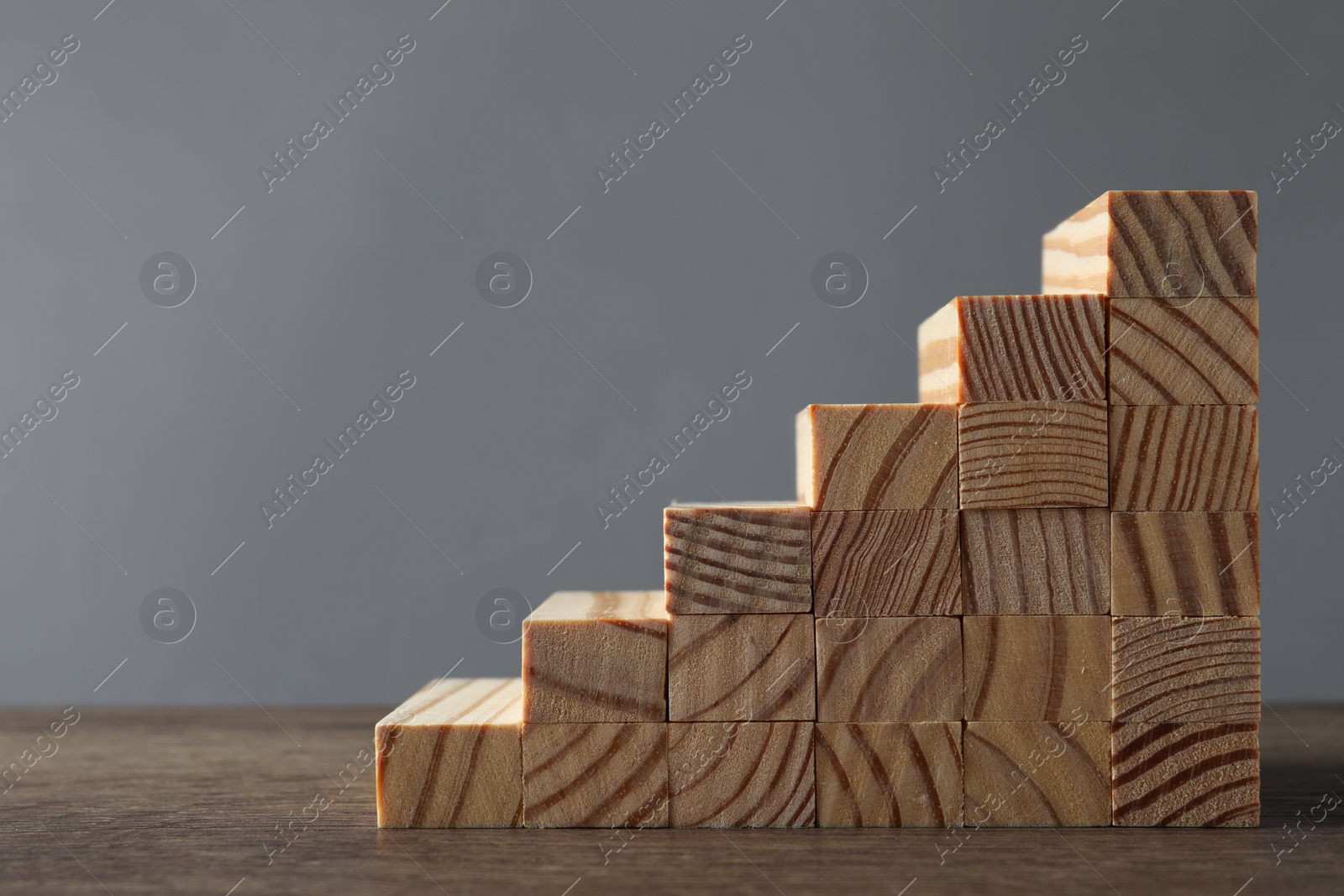 Photo of Steps made with wooden blocks on table against grey background, space for text. Career ladder