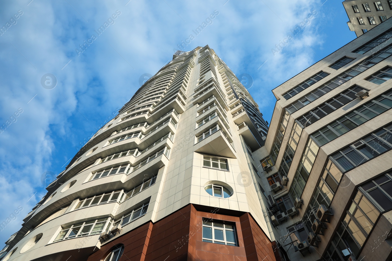 Photo of KYIV, UKRAINE - MAY 23, 2019: Modern dwelling building against sky with clouds