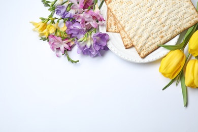 Composition with matzo and flowers on white background, top view. Passover (Pesach) Seder