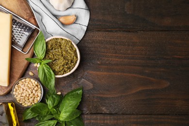 Tasty pesto sauce and ingredients on wooden table, flat lay. Space for text