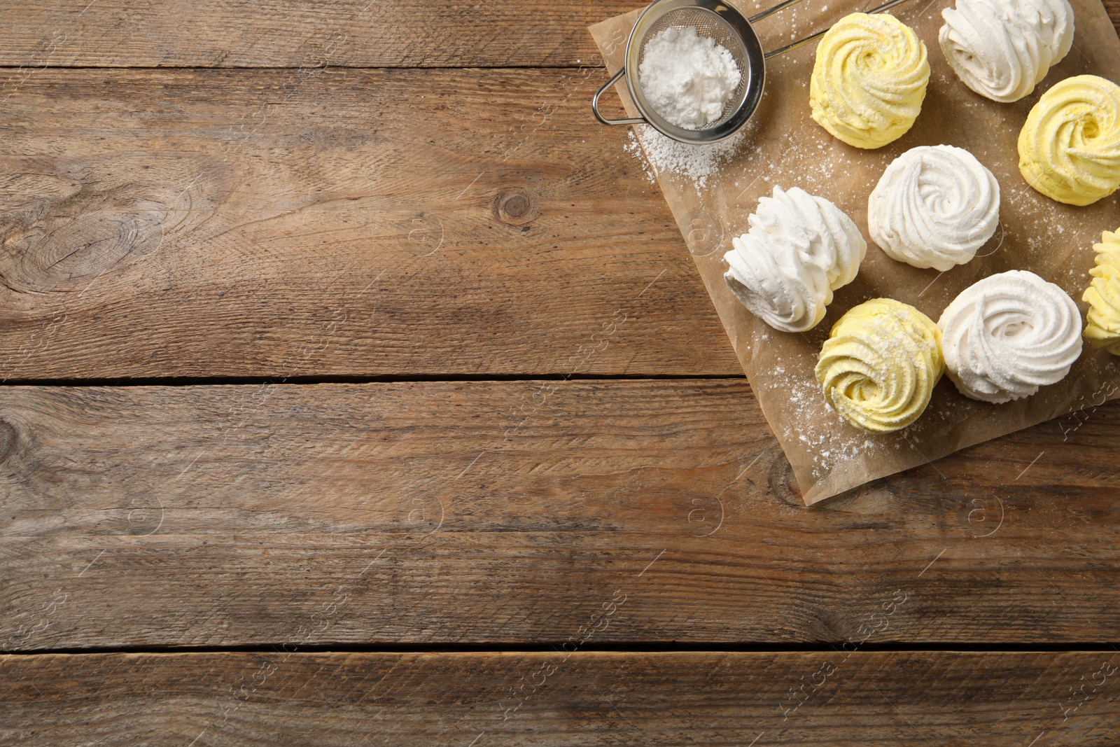 Photo of Delicious white and yellow marshmallows on wooden table, flat lay. Space for text