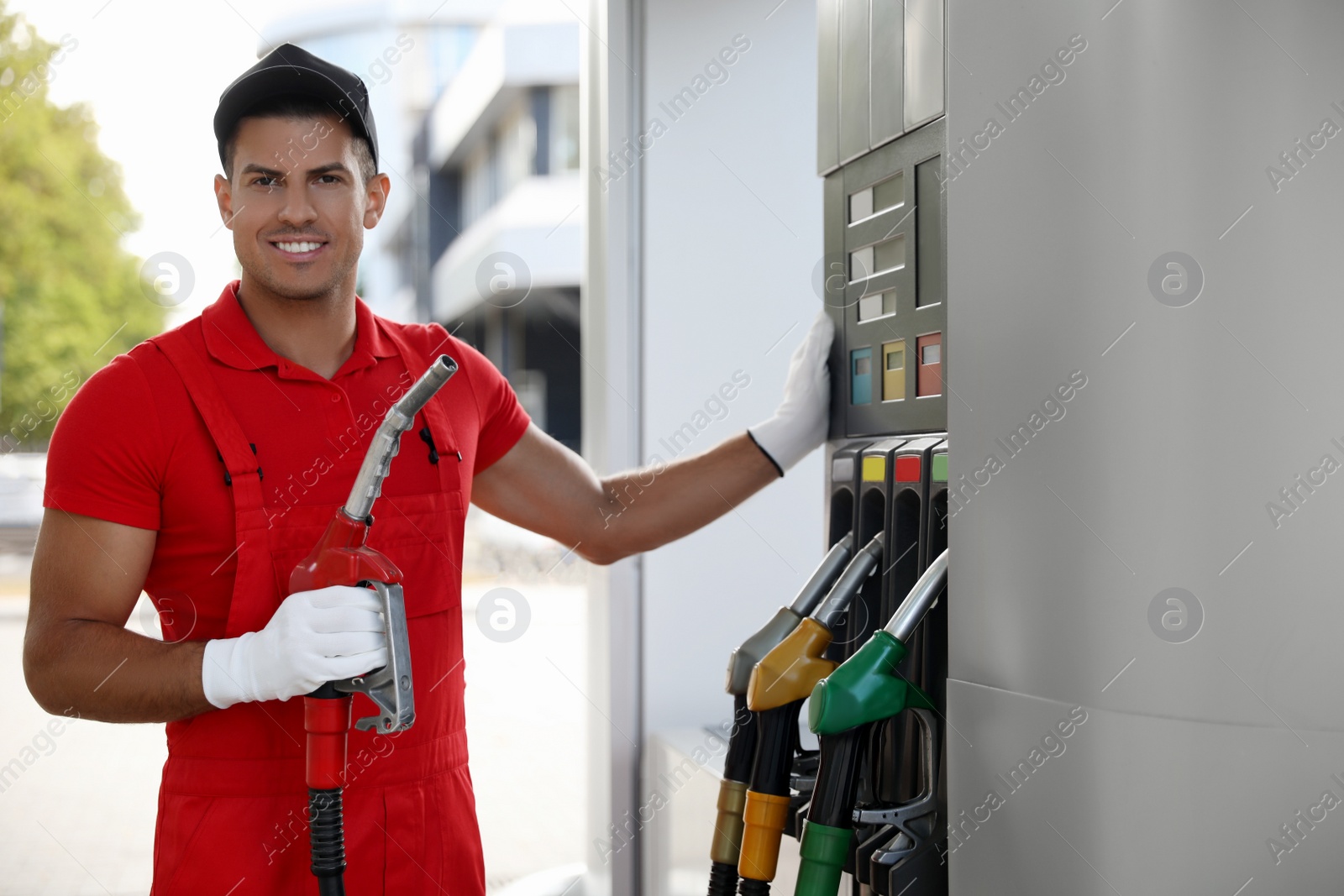 Photo of Worker with fuel pump nozzle at modern gas station