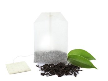 Photo of Tea bag and dry leaves on white background