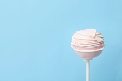 Photo of Sweet cake pop on light blue background, space for text