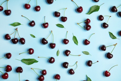 Flat lay composition with sweet red cherries on color background