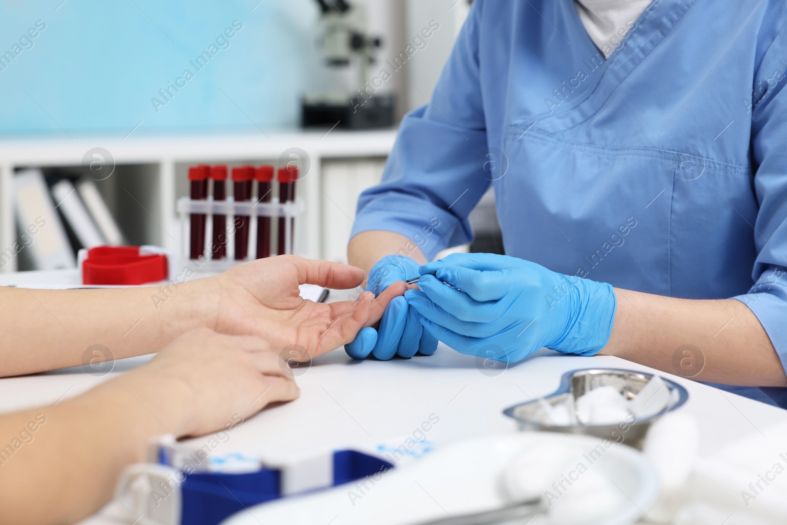 Photo of Laboratory testing. Doctor taking blood sample from patient at white table in hospital, closeup