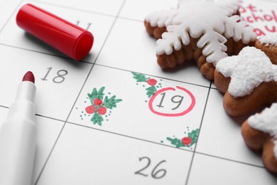 Photo of Saint Nicholas Day. Calendar with marked date December 19, marker and snowflake shape gingerbread cookies, closeup