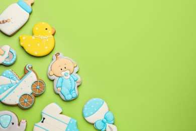 Photo of Cute tasty cookies of different shapes on light green background, flat lay with space for text. Baby shower party