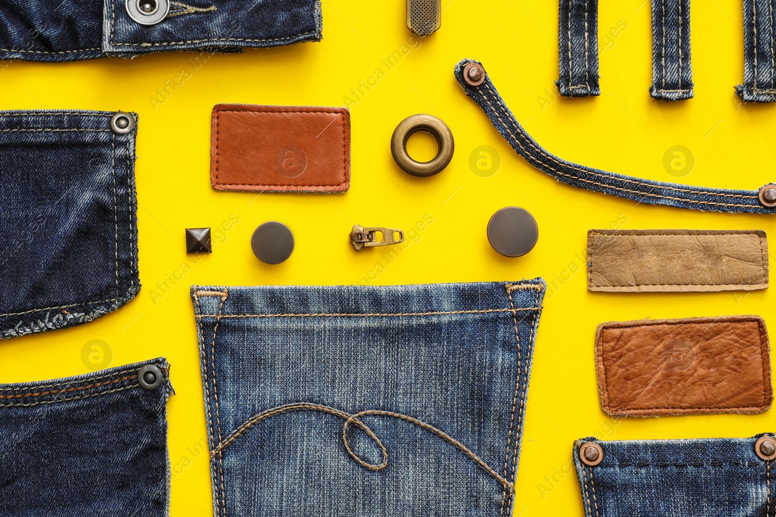 Photo of Flat lay composition with garment accessories and cutting details for jeans on yellow background