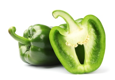 Cut and whole tasty green bell peppers on white background