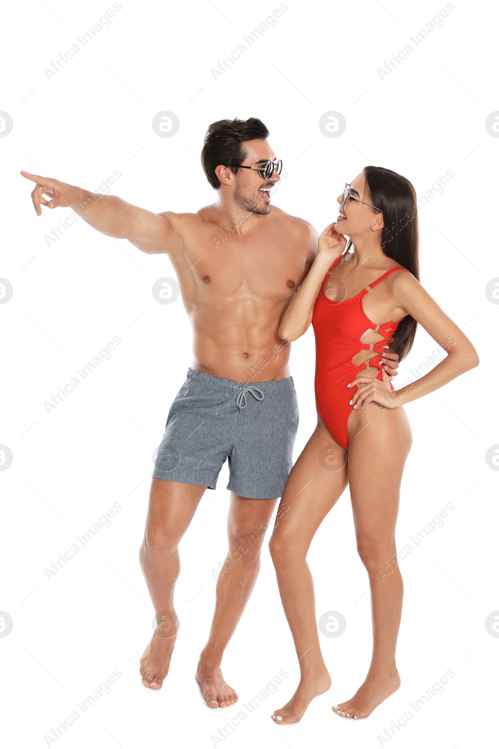 Photo of Young attractive couple in beachwear and sunglasses on white background
