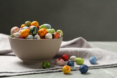 Photo of Ceramic bowl with delicious candies on grey table, space for text. Cooking utensil