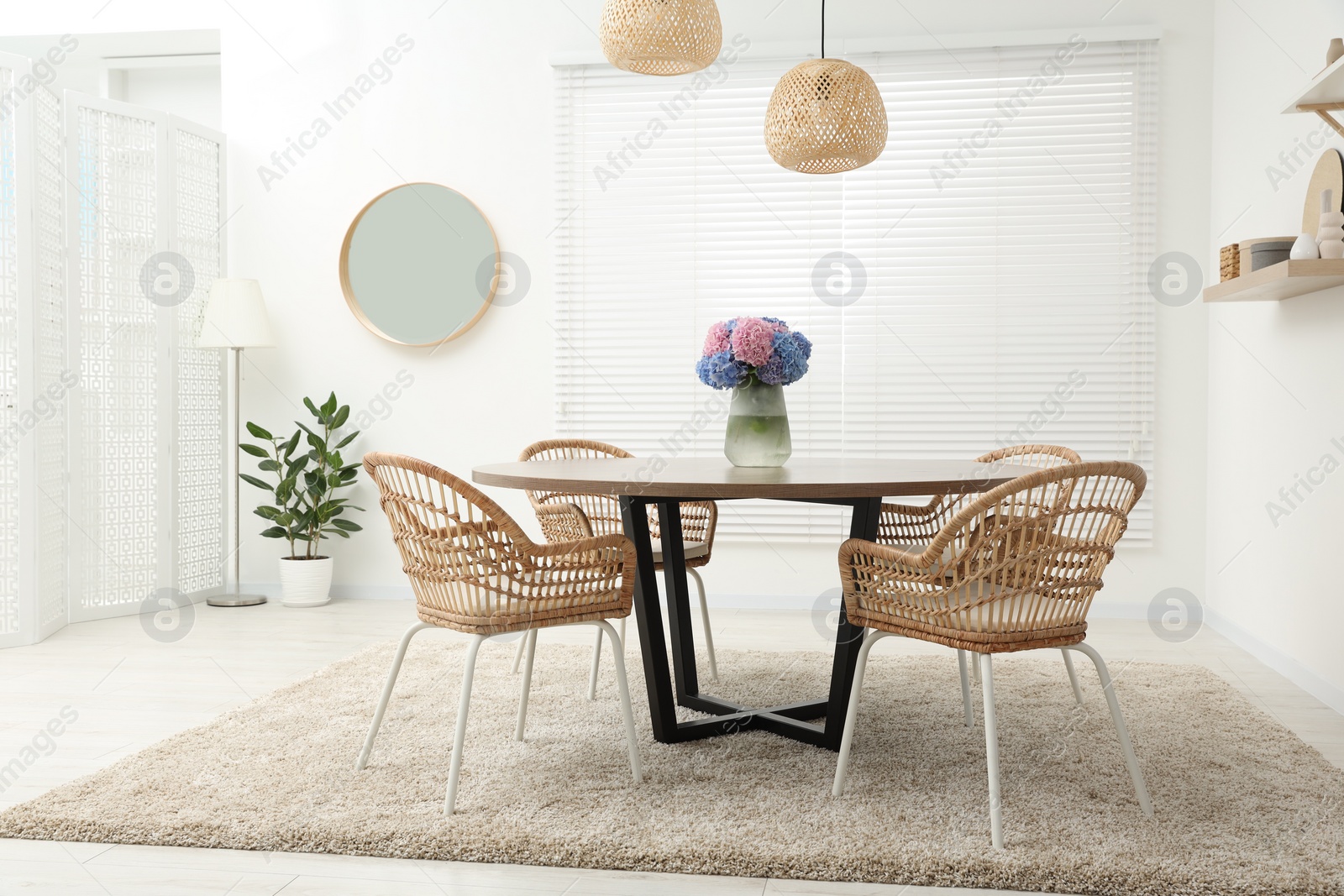 Photo of Table, chairs and vase of hydrangea flowers in dining room. Stylish interior