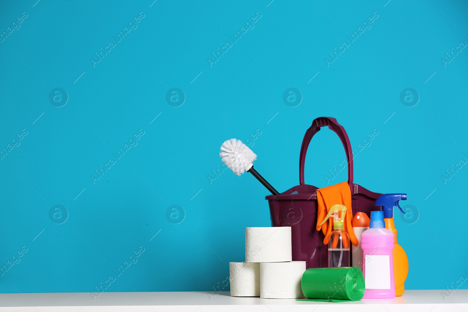 Photo of Bucket with cleaning supplies on color background