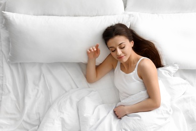 Photo of Portrait of beautiful young woman sleeping in large bed, above view