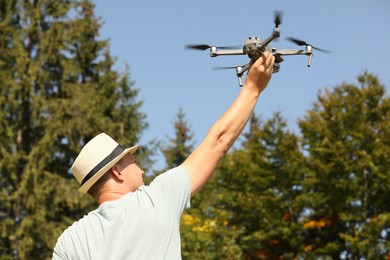 Photo of Man with drone outdoors on sunny day, back view
