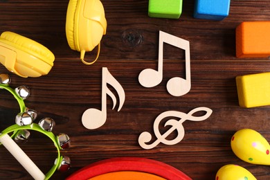 Photo of Baby song concept. Wooden notes, tambourines and toys on table, flat lay