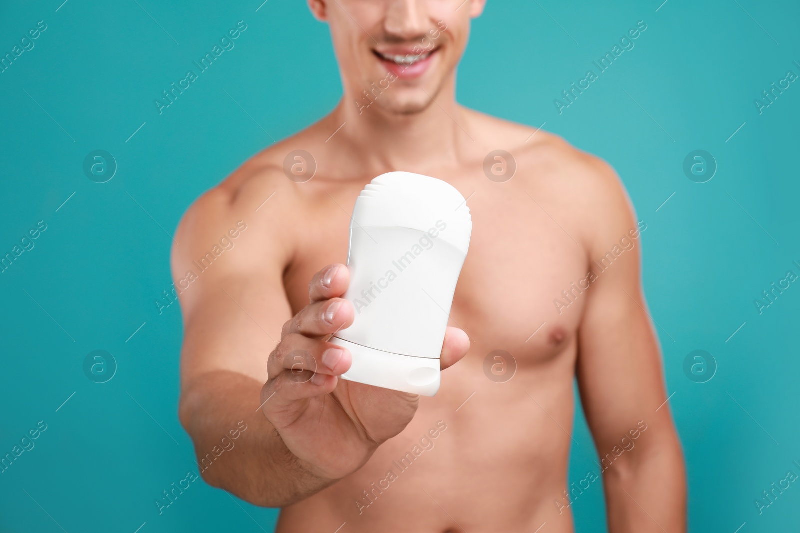 Photo of Young man with deodorant on light blue background, closeup