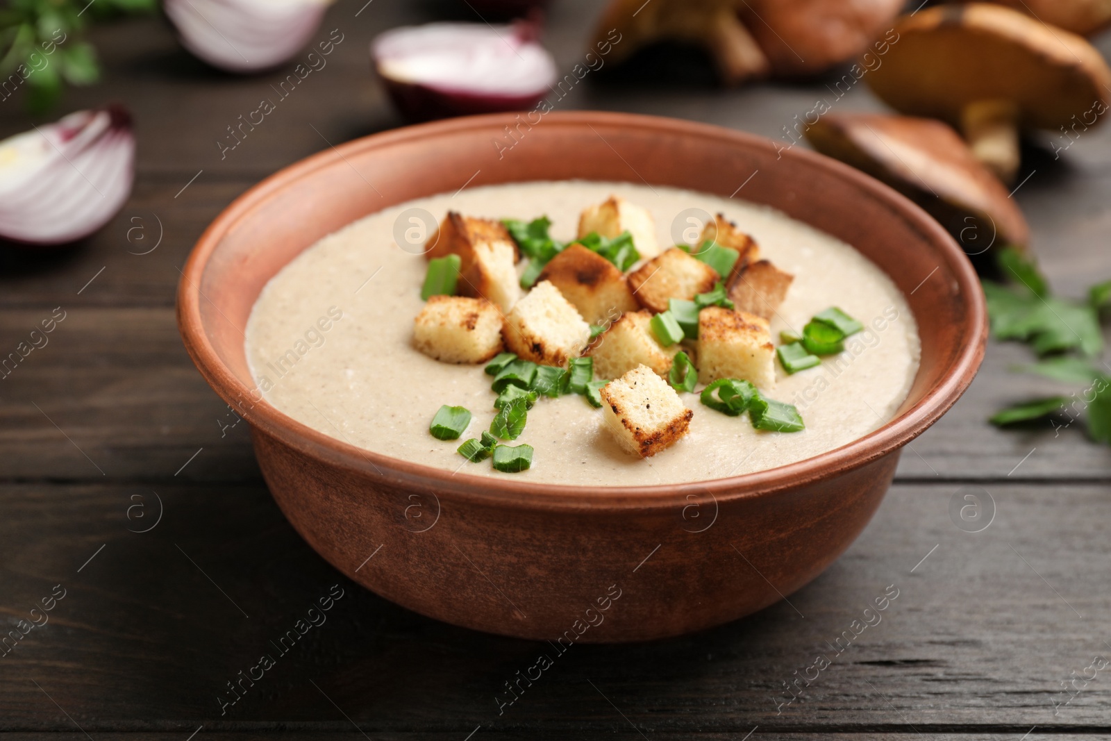 Photo of Bowl of fresh homemade mushroom soup on wooden table