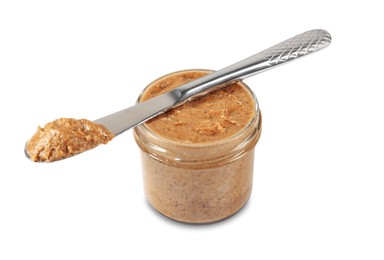 Delicious nut butter in jar and knife isolated on white