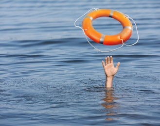 Image of Drowning man with raised hand getting lifebelt in sea, closeup