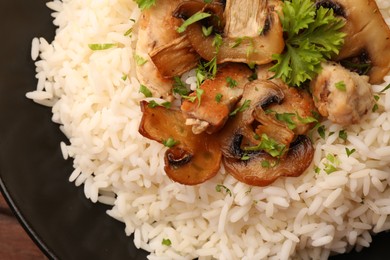 Photo of Delicious rice with mushrooms and parsley on plate, top view